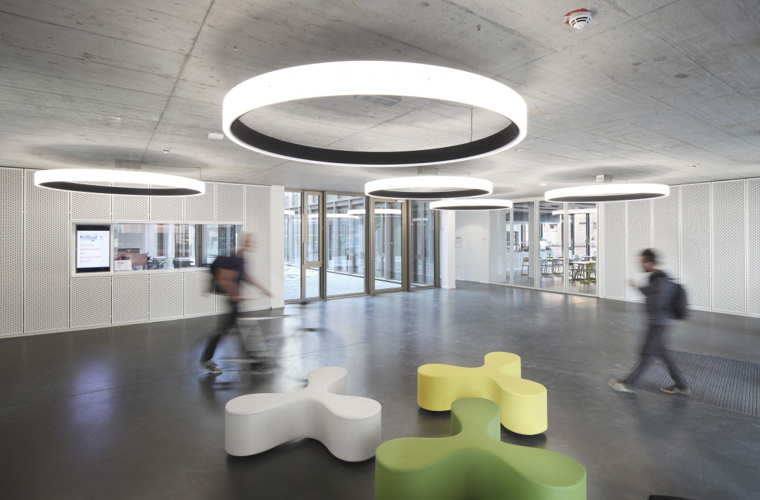 Foyer des Science Parks mit bunten Sitzmöbeln und Kreisrunden großen Deckenlampen.