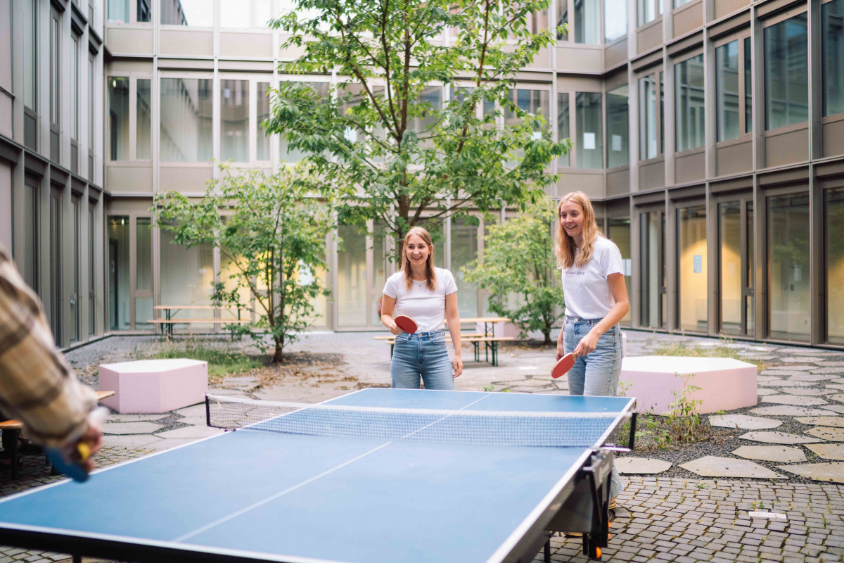 4 Männer beim Kicker-Spielen in einem Büroraum