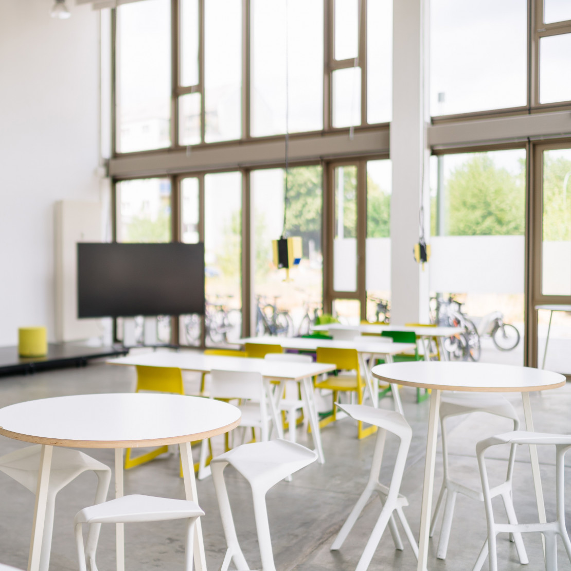 Man sieht die Tische, den Präsentationsrechner und die hohe Fensterfront des Idea Labs